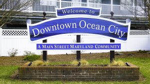 A sign that says "Welcome to Downtown Ocean City A Main Street Maryland Community" in white lettering