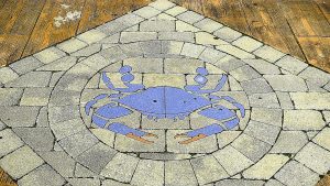 A brick paved blue crab in the boardwalk