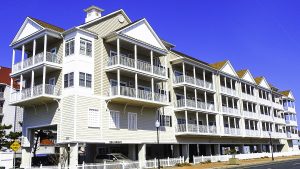 A series of condominiums on stilts with white porches and a white corner