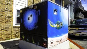 A painted utility box with sea turtles and beaches